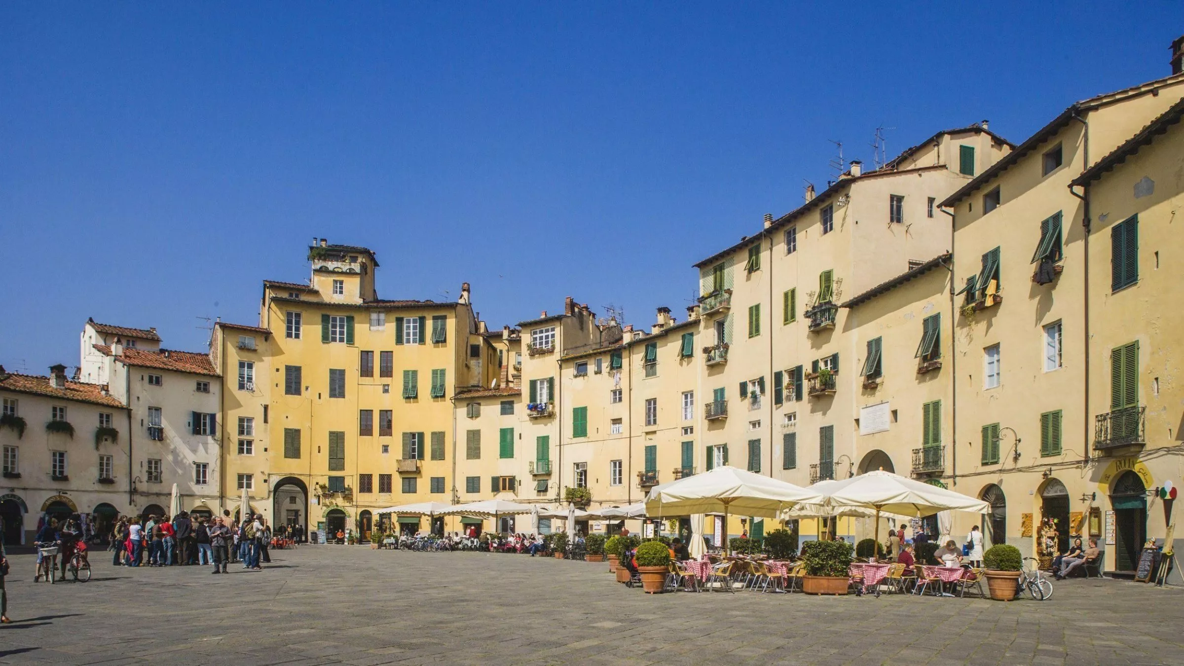 Woher die perfekte elliptische Form dieser Piazza in Lucca herrührt? Sie war einmal ein römisches Theater. Heute kann man auf der Piazza Anfiteatro Kaffee trinken