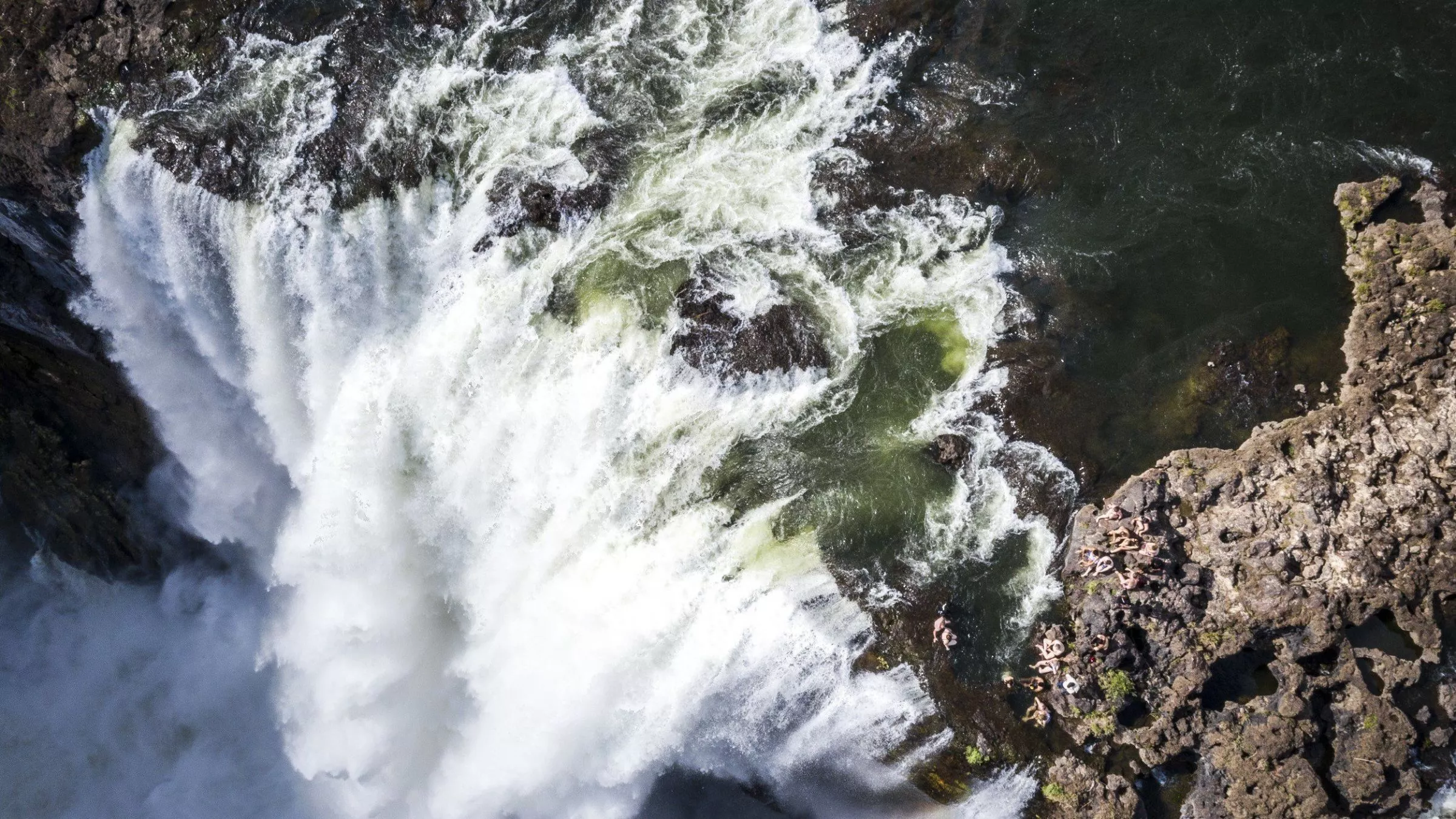 Viktoriafälle, an der Kante baden Menschen im Devil's Pool