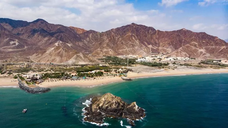 Am Strand von Al Aqah im Norden des Emirats, im Hintergrund erhebt sich das Hajjar-Gebirge