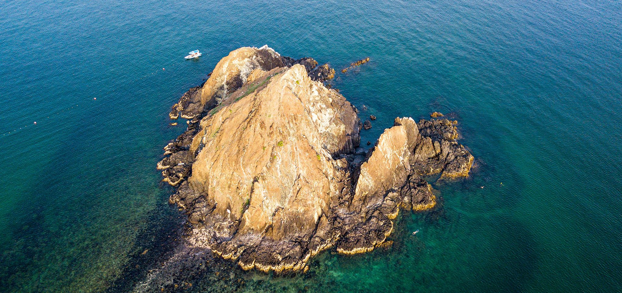 Mit etwas Fantasie kann man in den schroffen Felsen von Snoopy Island, an der Küste vor Al Aqah, Nase, gewölbten Bauch und Schwanz des gleichnamigen Comic-Hundes erkennen