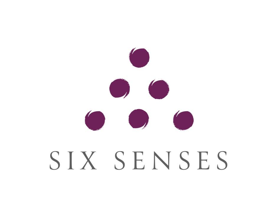Six Senses Logo: sechs violette Kreise in Dreiecksform über dem Schriftzug SIX SENSES.