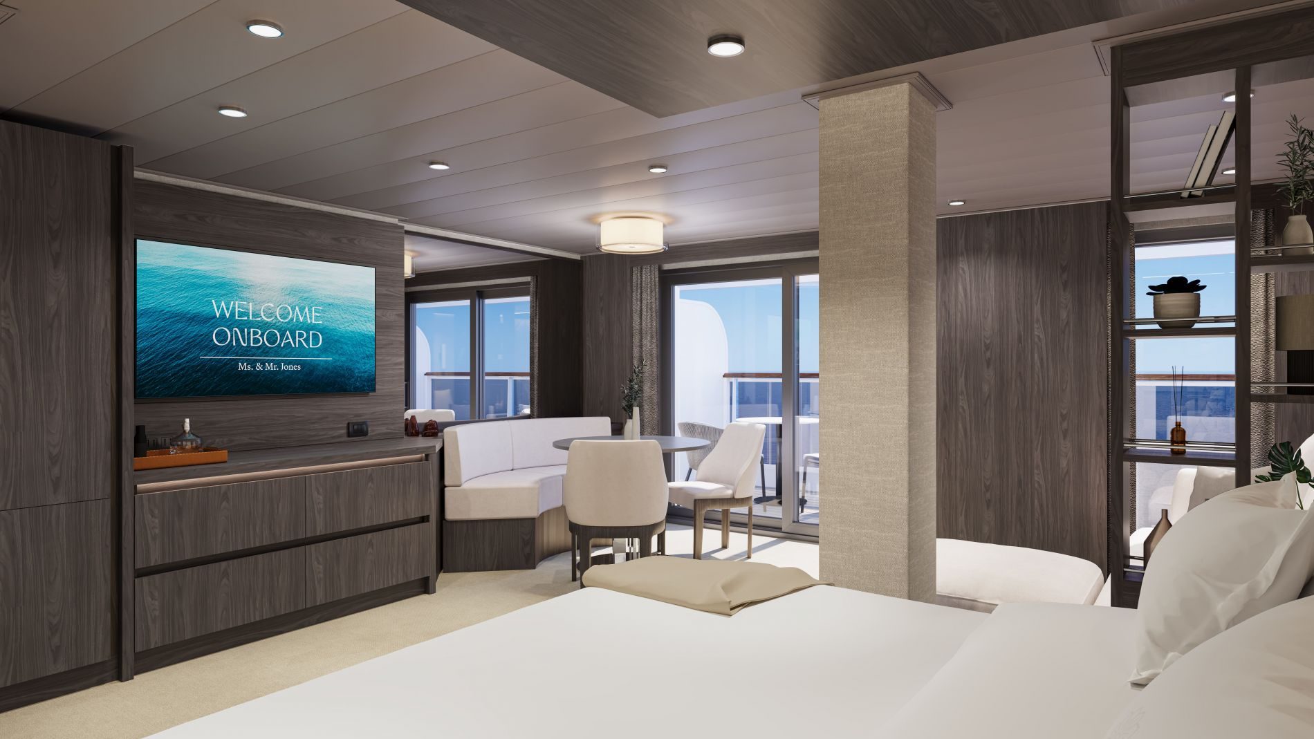 Moderne Kreuzfahrt-Suite mit TV Anzeige Welcome Onboard, Sitzecke, Bett im Vordergrund, dunkle Holzpaneele und Balkonblick