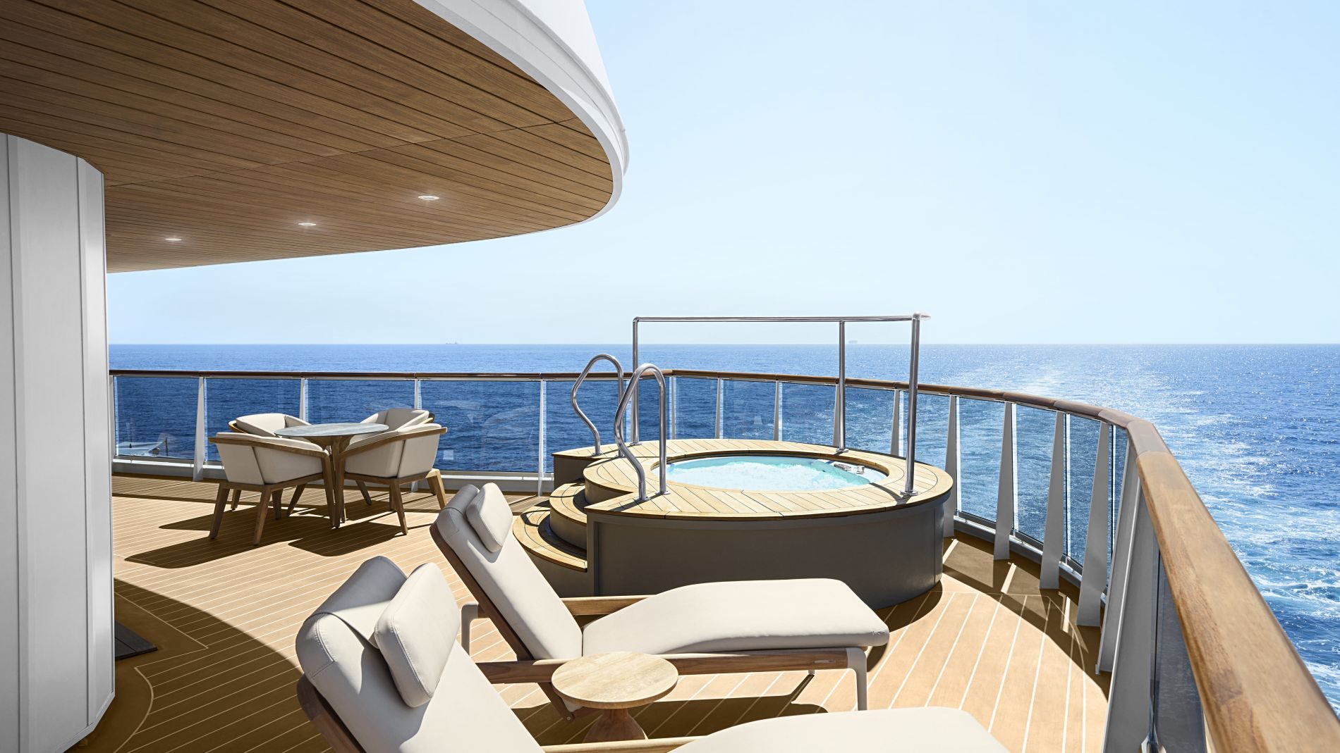 Oberdeck einer Explora Journeys Yacht: Whirlpool, Liegen und Sitzgruppe auf Holzdeck mit Meerblick.