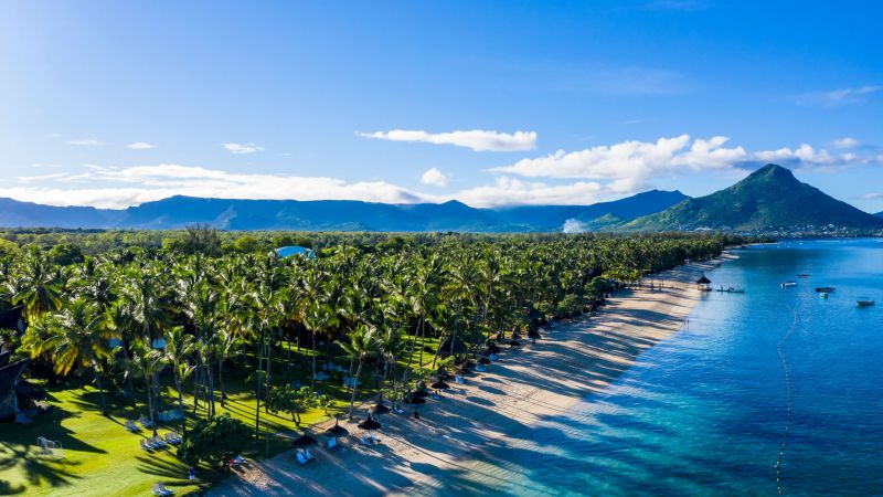Strand von Flic en Flac, Mauritius: Palmen, Sand, türkisblaues Meer, dahinter Bergkette – Deals Strand von Flic en Flac, Mauritius: Palmen, Sand, türkisblaues Meer, dahinter Bergkette – Deals