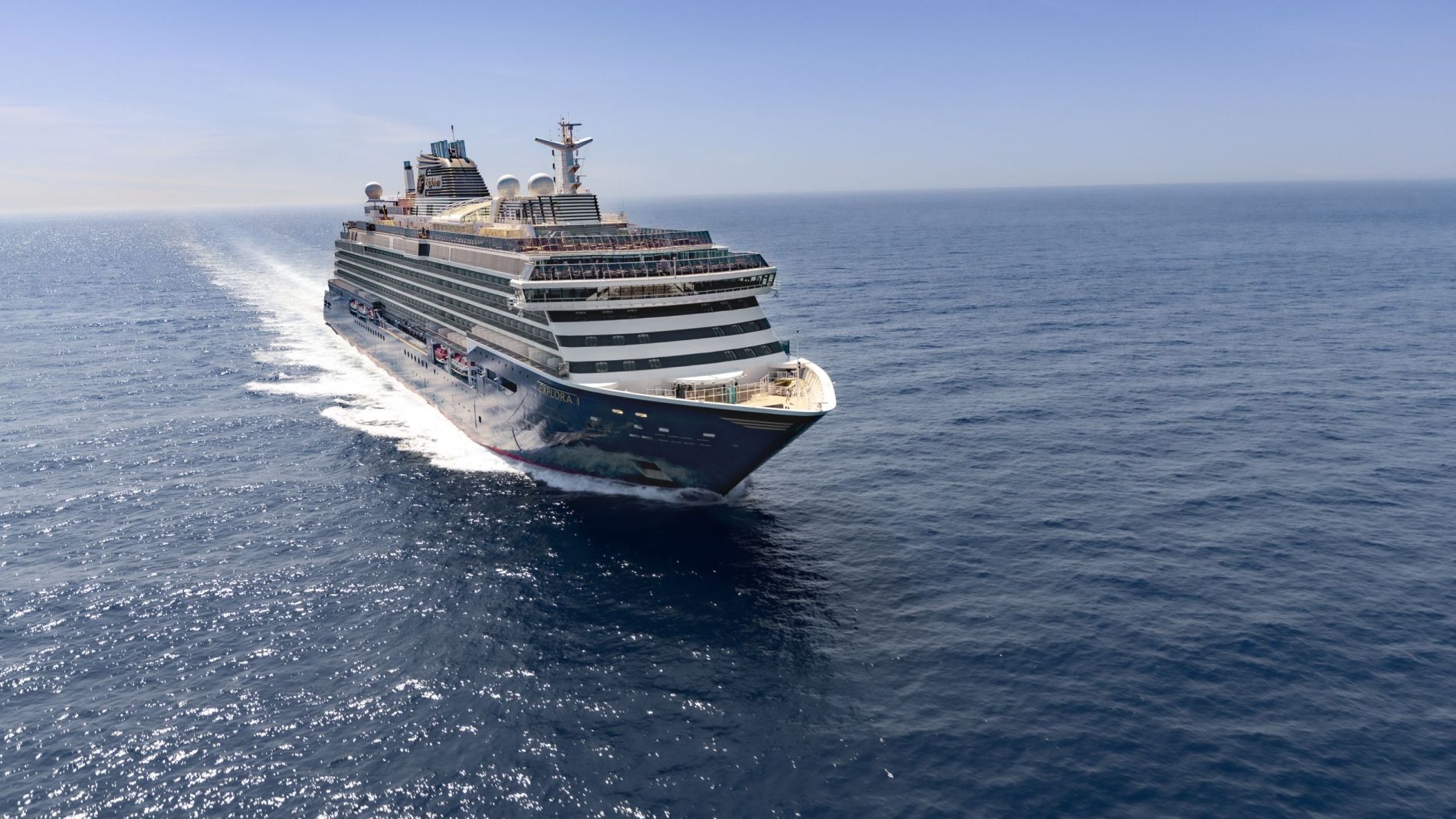 EXPLORA I Kreuzfahrtschiff auf offener See, seitliche Perspektive mit mehreren Passagierdecks und Decksbereichen sichtbar