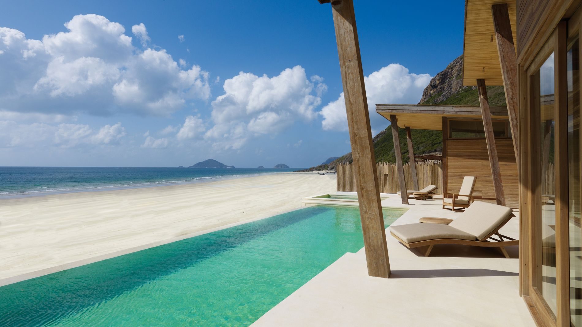 Strandvilla mit privatem Pool, Holzarchitektur, Liegen am Pool, Meer- und Sandstrandblick am Con Dao.