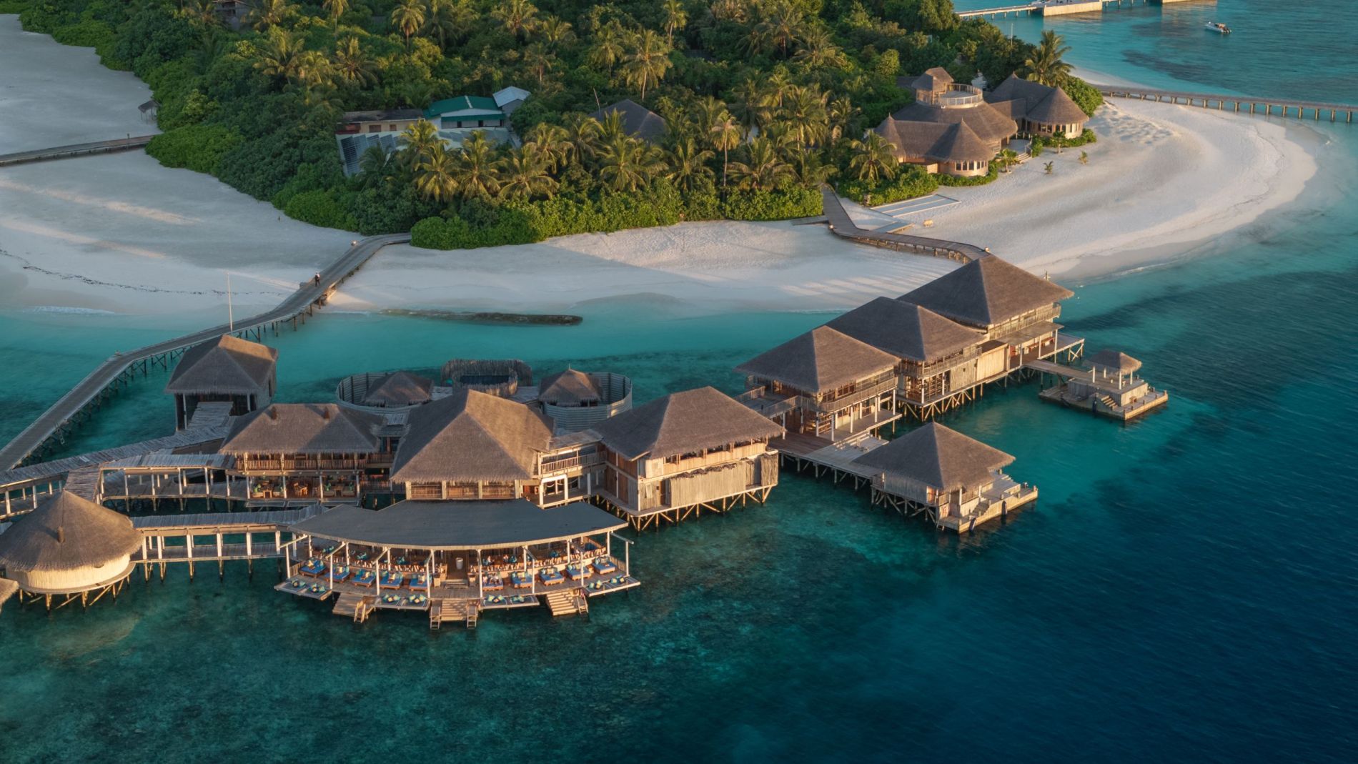Luftaufnahme des South Palm Resort Maldives mit über Wasser Bungalows, Brücken, Strand und türkisblauem Meer.