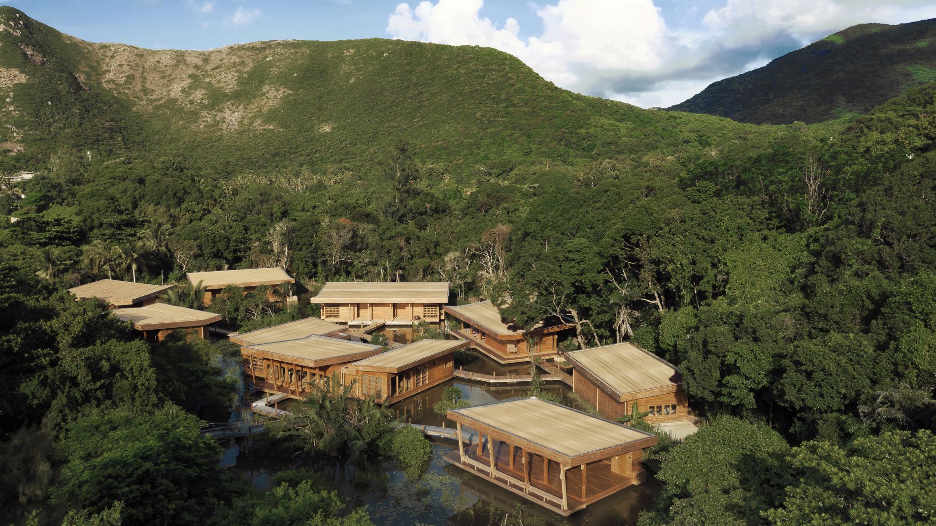 Spa-Resort aus Holzhäusern im Dschungel von Con Dao, Six Senses, umgeben von grünem Wald und Wasserläufen.