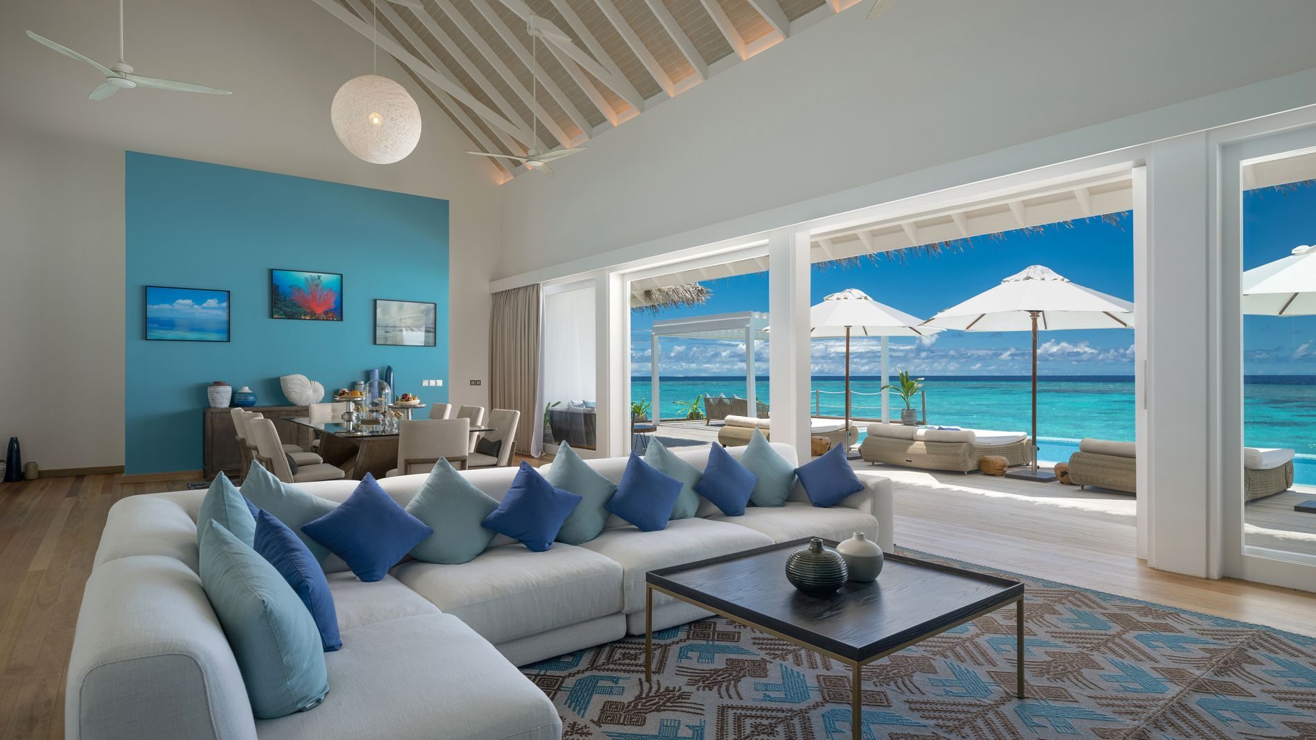 Wohnzimmer im Baglioni Resort Maldives: Terrasse mit Meerblick, weiße Sofas, blaue Kissen, blaue Akzentwand.