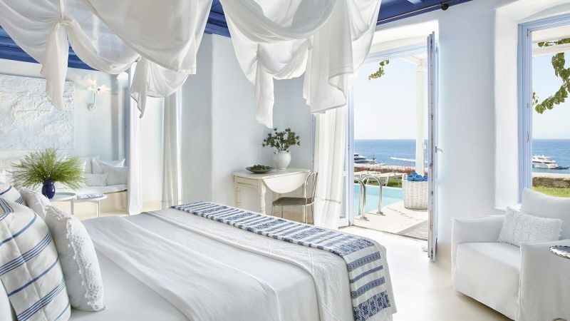 Helles, elegantes Zimmer mit Meerblick, weißen Wänden, blauen Decken und stilvollen Möbeln. Helles, elegantes Zimmer mit Meerblick, weißen Wänden, blauen Decken und stilvollen Möbeln.